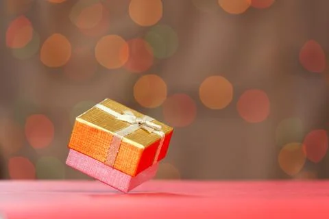 Gift box with bow on blurred bokeh background. Stock Photos
