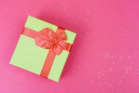 Gift box with bow on colored background with sparkles. 写真素材
