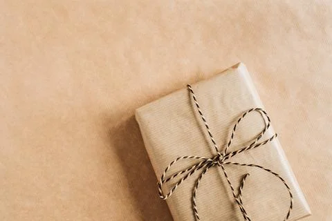 Gift box with bow on craft paper background. Christmas / New Year minimal com Stock Photos
