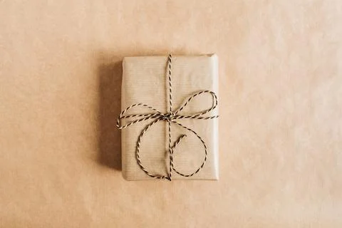 Gift box with bow on craft paper background. Christmas / New Year minimal com Stock Photos