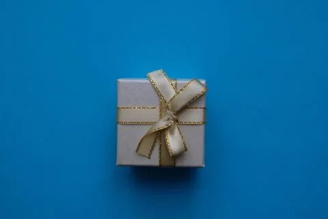 Gift box with a bow on a light blue background Stock Photos