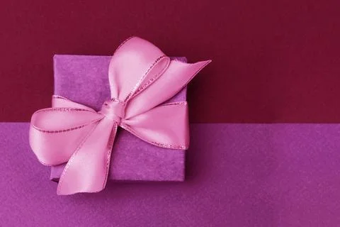 Gift box with bow on paper background. Stock Photos