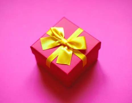 Gift box with bow on pink background Stock Photos