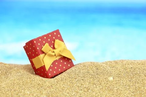 Gift box with bow on the sand Stock Photos