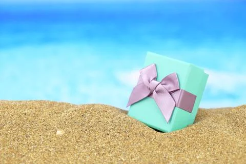Gift box with bow on the sand Stock Photos