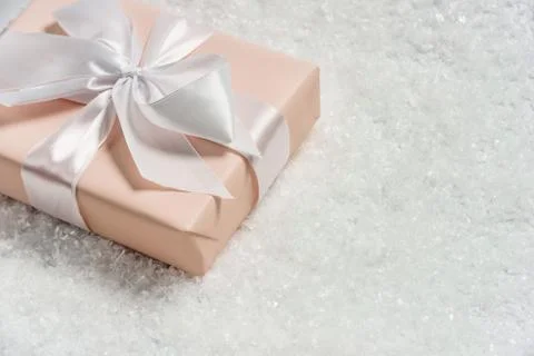 Gift box with a bow in the snow. Stock Photos