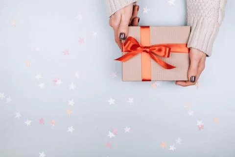 Gift box with bow in woman's hands. Stock Photos