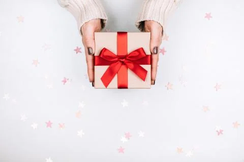Gift box with bow in woman's hands. Stock Photos