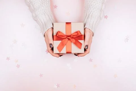 Gift box with bow in woman's hands. Stock Photos