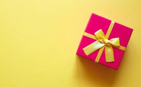 Gift box with bow on yellow background Stock Photos