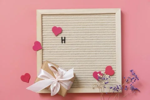 Gift box with bows small hearts and gypsophila flowers on pink background. Stock Footage 239981556