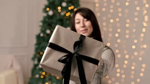 A gift box close up in the hands of a beautiful woman on a New Year holiday Stock-Footage 214473573