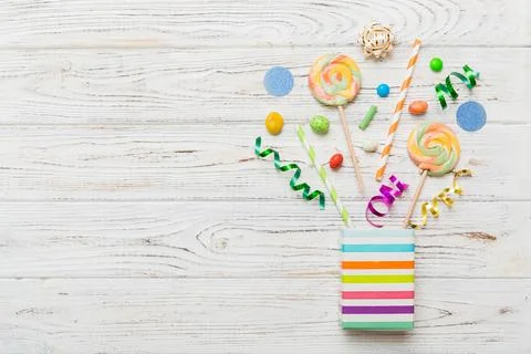 Gift box in corner full of assorted traditional candies falling out on colo.. Stock Photos