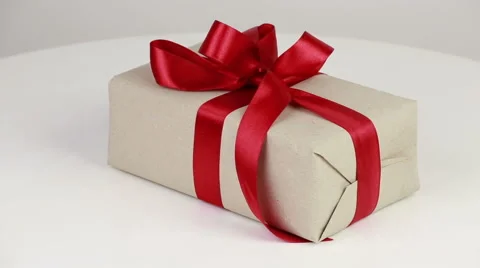 Gift box covered with wrapping paper and red bow Stock Footage 58672254