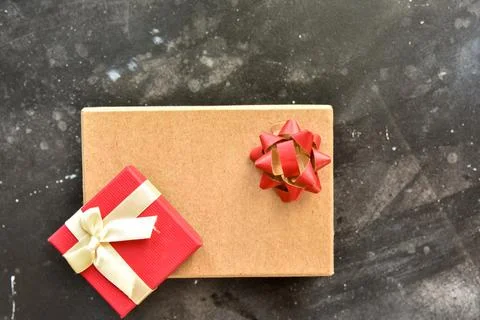 Gift box on a dark background, decorated with a textured bow. Stock Photos