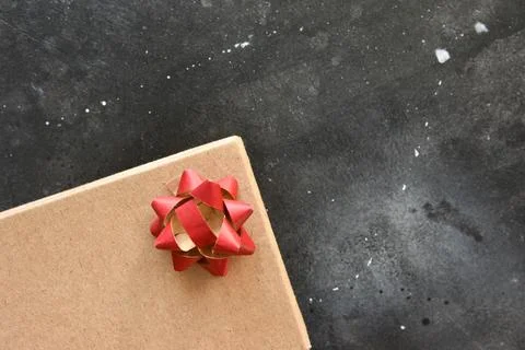 Gift box on a dark background, decorated with a textured bow. Stock Photos