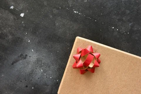 Gift box on a dark background, decorated with a textured bow. Stock Photos