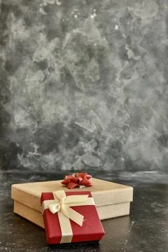 Gift box on a dark background, decorated with a textured bow. Stock Photos