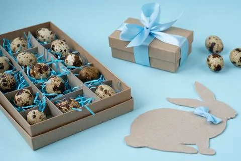 Gift box with Easter eggs, Easter Bunny and gift on a blue background. Creati Stock Photos
