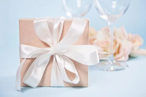 Gift box with empty two wineglasses and flowers on the background. Romantic d Stock Photos