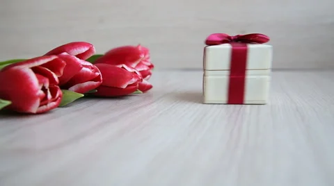 Gift box enters the frame to the colors, and then hand picks up a gift. Stock Footage 60065667