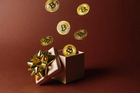 Gift box with flying bitcoins Stock Photos