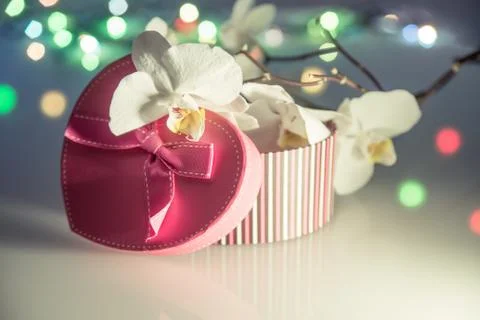 Gift box in form of heart on the background of the white orchid 写真素材