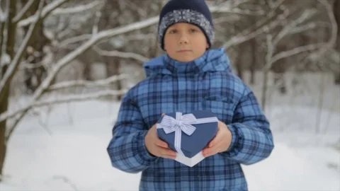 Gift box in the form of a heart in the hands of a child Stockbeeldmateriaal 84743091