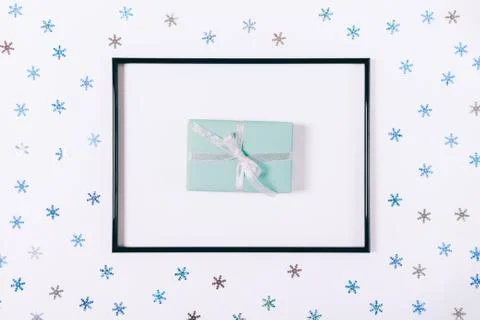 Gift box in a frame on a white table Fotos Stock
