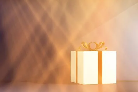 Gift box with a gold bow in light rays Stockillustratie