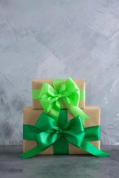 Gift box with green bow on grey concrete background Stock Photos