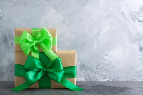 Gift box with green bow on grey concrete background Stock Photos
