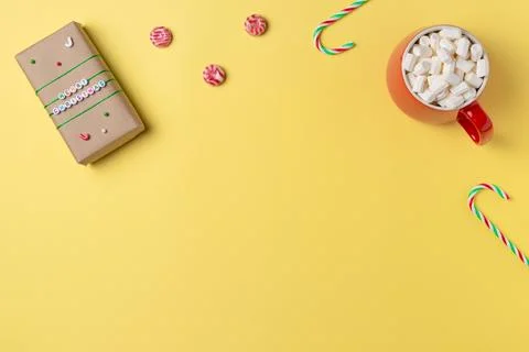 Gift box, marshmallow and candy on yellow background from above. Flat lay, .. Stock Photos