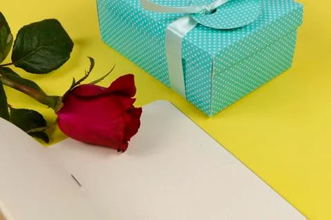 Gift box next to notepad and a flower Foto stock