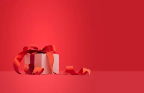 Gift box or present box with red ribbon on red background. Stock Photos