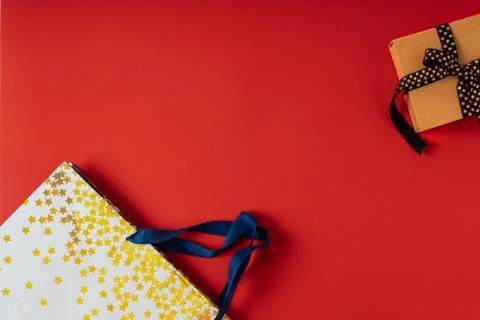 Gift box or present box with black golden ribbon on red background. Stock Photos