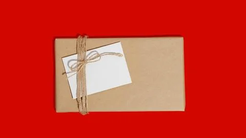 Gift box or present wrapped in craft paper with blank white card. Christmas Stock Photos