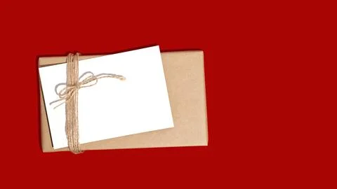 Gift box or present wrapped in craft paper with blank white card. Christmas Stock Photos