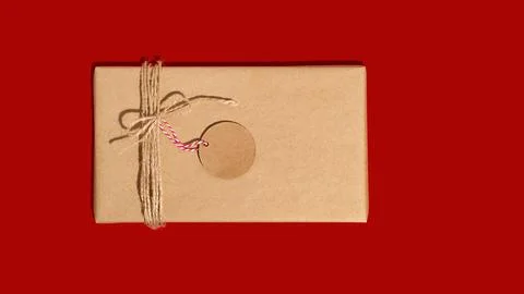 Gift box or present wrapped in craft paper with tag or label. Christmas Stock Photos