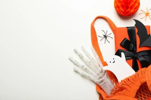 Gift box, paper ghost and bat in shopping bag on white background, space fo.. Stock Photos