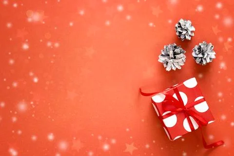 Gift box with pine cones on red background and space for text. Christmas back Stock Photos