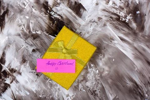 Gift box with a pink note on an abstract background depicting celebration. Stock Photos