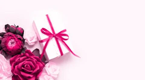 Gift box present decorations flatlay. Gift, pink ribbon, pink flowers top vie Stock Photos