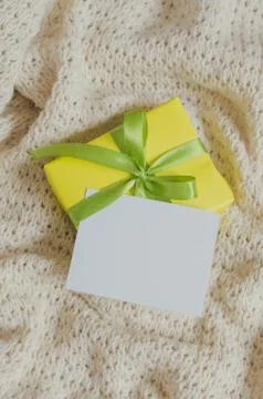 Gift Box. Present With Empty Postcard on Knitted blanket background. Stock Photos