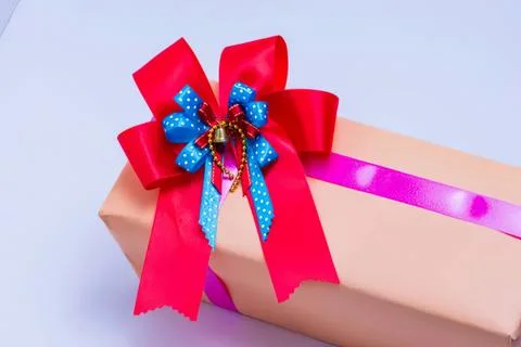 Gift box with red and blue ribbon and bow on pastel background Stock Photos