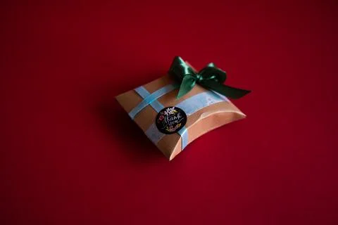 Gift box on a red background. Craft paper and handmade decoration Stockfoto's