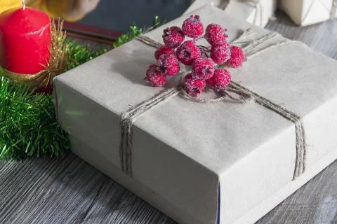 A gift box with red berries, packed in kraft paper and tied with linen twine  Stock Photos