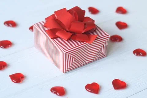 Gift box with red bow and hearts on light background Stock Photos