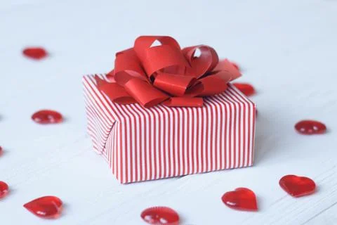 Gift box with red bow and hearts on light background Foto stock