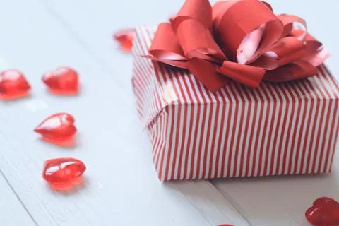 Gift box with red bow and hearts on light background Stock Photos
